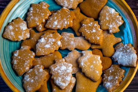 Cookies in the form of Christmas trees are lying on a blue plate close-up. High quality photo
