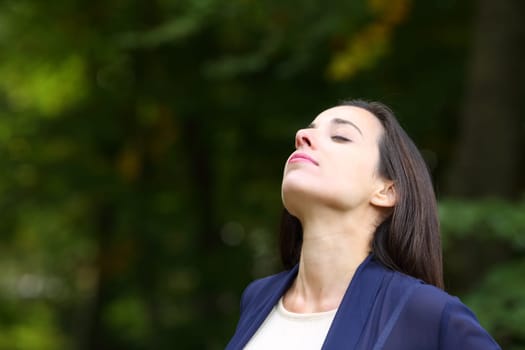 Relaxed woman breathing fresh air in nature