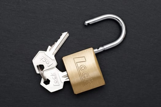 Steel padlock with key on a black background