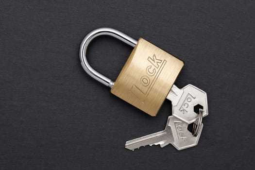 Steel padlock with key on a black background