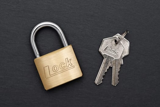 Steel padlock with key on a black background