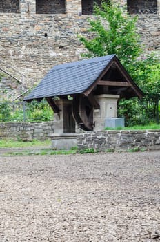 Old water well in the garden. Vintage draw well in european village