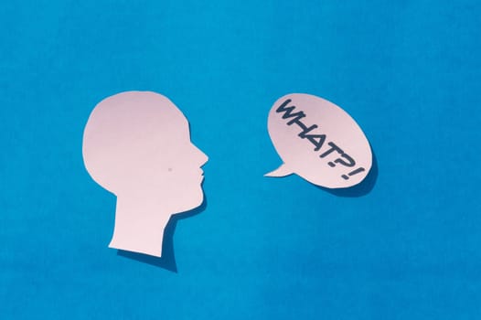 Paper Human face with What Question Mark on speech bubble isolated on blue background. Conceptual images showing to express doubt or uncertainty about something.