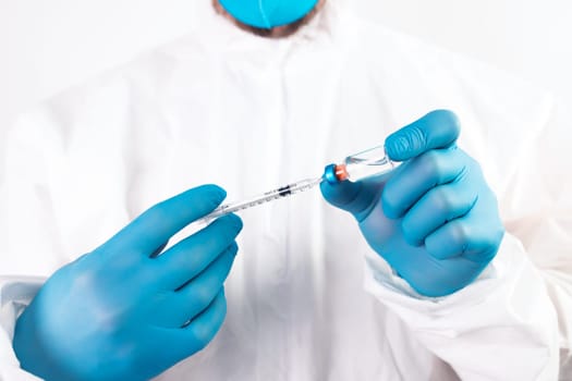 COVID-19 coronavirus vaccine. Vaccination concept. Doctor's hand in blue gloves hold medicine vaccine vial bottle and syringe.