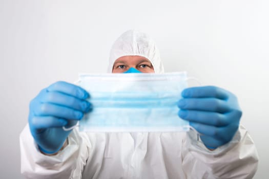 Doctor hand wear blue medical gloves holds antivirus face mask for pandemic diseases. Outbreak, Covid19 concept