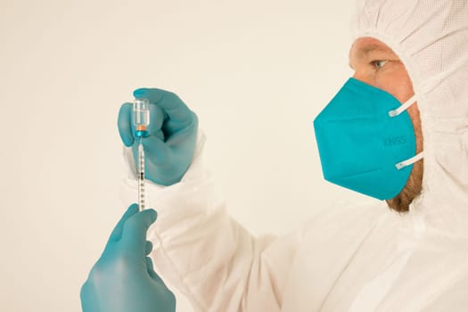 COVID-19 coronavirus vaccine. Vaccination concept. Doctor's hand in blue gloves hold medicine vaccine vial bottle and syringe.