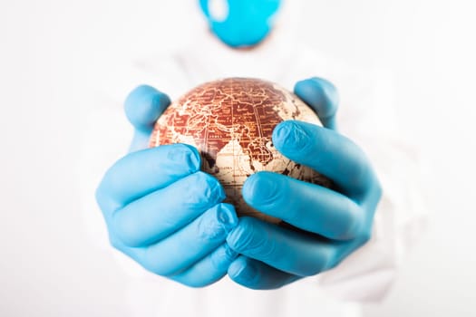 World epidemic danger concept. Hands of doctor protecting planet Earth.