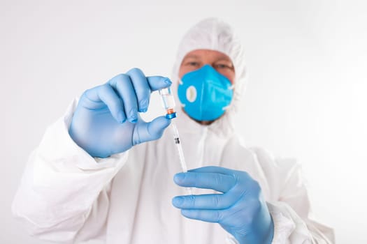 COVID-19 coronavirus vaccine. Vaccination concept. Doctor's hand in blue gloves hold medicine vaccine vial bottle and syringe.