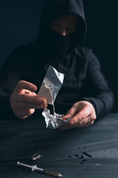 Addict/junkie man preparing drugs. The concept of crime and drug addiction.