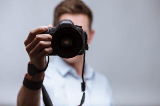 Photographer holding dslr camera on bright backround