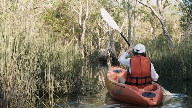 Back young adult woman paddling kayaking canoe on a lake on summer day in rural landscape, adventure travel leisure enjoying concept, lifestyle sport vacation