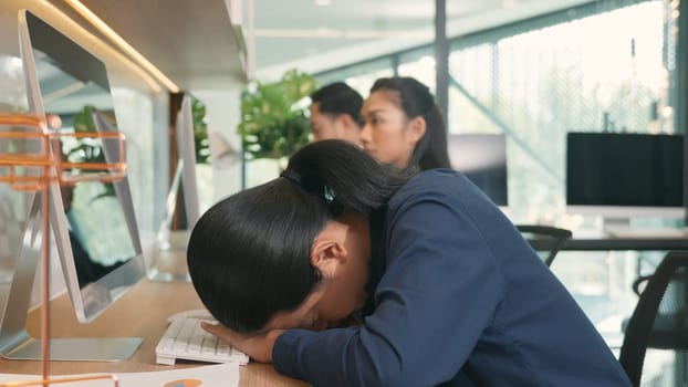 Tired businessman yawning during working on computer sitting at desk office and the team working with PC computer, business man yawning at workplace feeling no motivation or lack of sleep tired