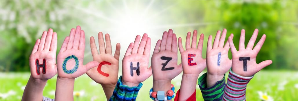 Children Hands Building Colorful German Word Hochzeit Means Wedding. Sunny Green Grass Meadow As Background