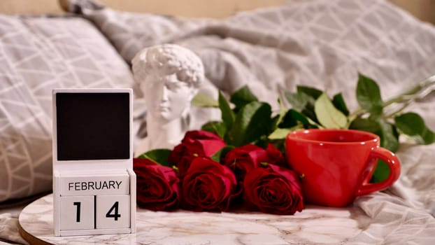 Festive Flatlay, composition for Valentine's Day on February 14. Coffee in a red cup and red rose flowers at home in bed
