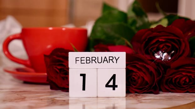 Background Festive Flatlay, composition for Valentine's Day on February 14. Coffee in a red cup, red rose flowers and diamond heart earrings at home in bed