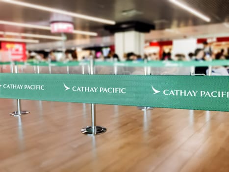 Hong Kong, CHN, July 2019: Green belt barrier with white Cathay Pacific airlines logo. Cathay Pacific is the flag carrier airline of Hong Kong. Travel and airport security