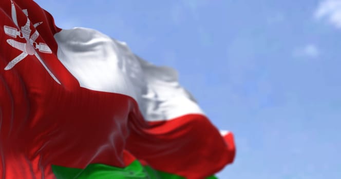 Detail of the national flag of Oman waving in the wind on a clear day. Democracy and politics. Patriotism. Selective focus. Western Asian country.