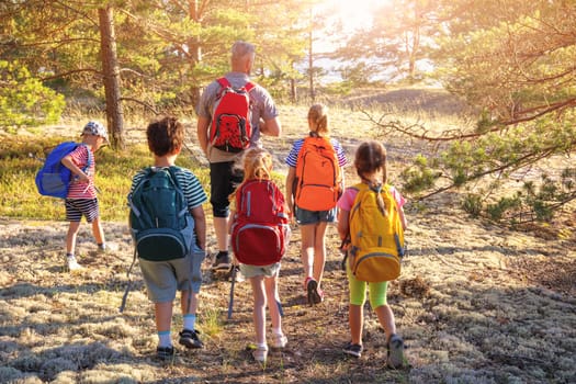 Groupof the people with backpacks on the nature near the sea. Concept of the family hiking and children's scout camping.