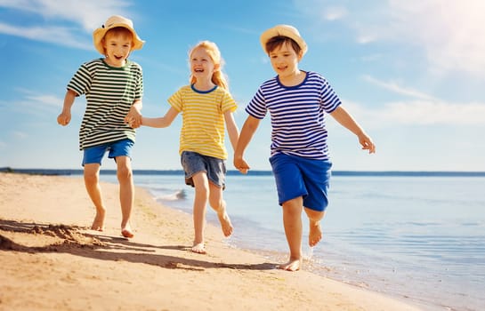 Cute children running along the sea coast. Concept of the family vacation and friendship.