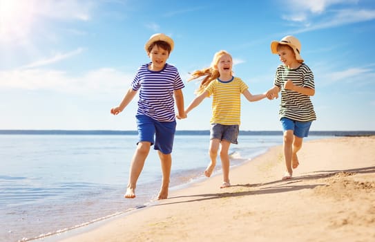 Cute children running along the sea coast. Concept of the family vacation and friendship.