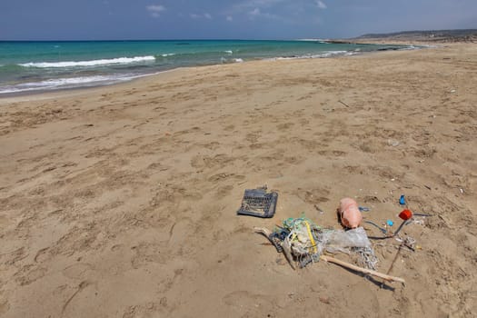 Beautiful empty wild beach in Karpass, Cyprus, with rubbish on the sand. Ocean littering concept.