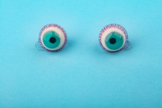 Decorative fruit candy eyes over light blue background. Conceptual photo using for funny celebration themes.