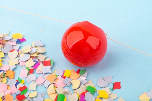 Red Nose with confetti over light blue background.