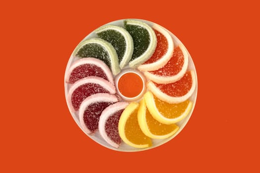 Colorful slices from fruit jelly candy isolated on orange background