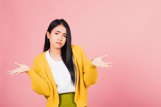 Asian portrait beautiful cute young woman teen shrugging with spread hands she shocked dont understand and confused studio shot isolated on pink background, female doubt with copy space