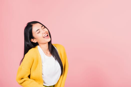Happy Asian portrait beautiful cute young woman standing winning and surprised excited screaming laughing look face up, studio shot isolated pink background, Thai female smiley funny with copy space