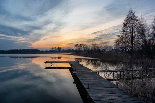 Beautiful sunset and clouds over the lake with pier, Stankow, Poland