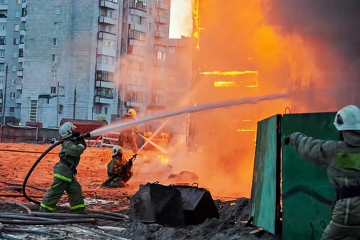 Firefighters extinguish a fire in a two-story wooden house. High quality photo