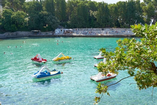 Bathing bay with pedal boats on the coast of the Adriatic Sea near the town of Krk in Croatia