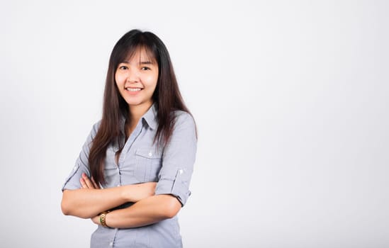 Woman standing her smile confidence with crossed arms isolated white background, Asian happy portrait beautiful young Thai female looking to camera in studio shot on white background and copy space