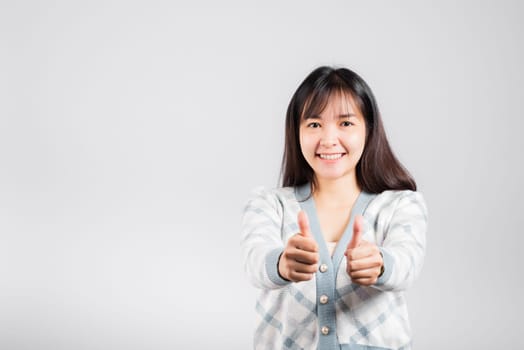 Happy woman smile showing finger thumbs up, Portrait Asian beautiful young female successful like finger gesture, OK sign to agree studio shot isolated on white background with copy space