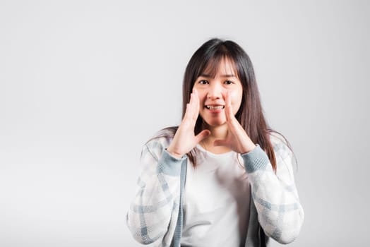 Happy woman hand on mouth talking whisper secret rumor, Asian beautiful young female excited tell gossip, studio shot isolated on white background with copy space