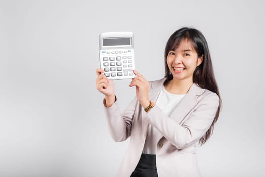 Tax day concept. Woman confident smiling holding electronic calculator, Portrait excited happy Asian young female studio shot isolated on white background, Business Account and finance counting income