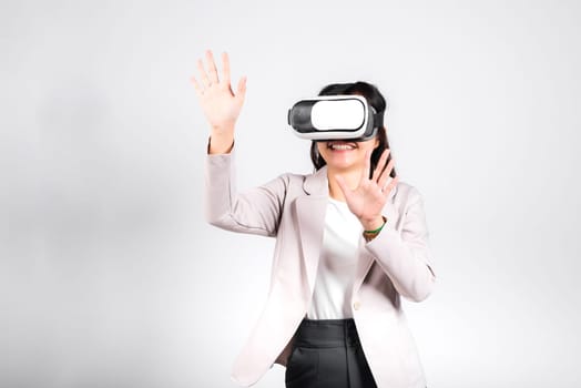 Smiling woman confidence excited wear VR headset device touching air during virtual reality experience isolated white background, Asian happy portrait female playing video game studio shot, copy space