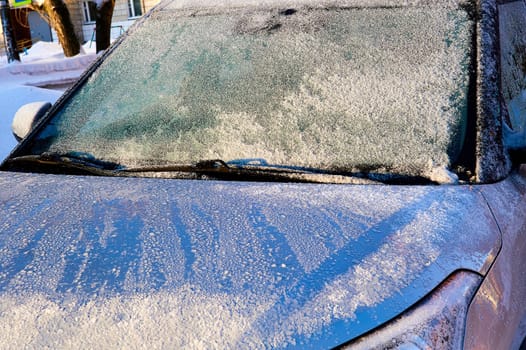 The windshield covered with frost at the car on a sun winter day. High quality photo