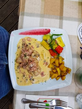 Fried potatoes and schnitzel with sauce