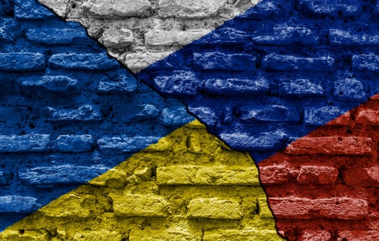 the flags of Ukraine and Russia painted on a ruined bricked wall and divided by a diagonal crack. International diplomatic relations.