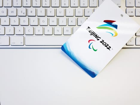 Beijing, China, february 2022: Blank white badge with the Beijing 2022 winter paralympic games logo artwork on a computer keyboard. International event.
