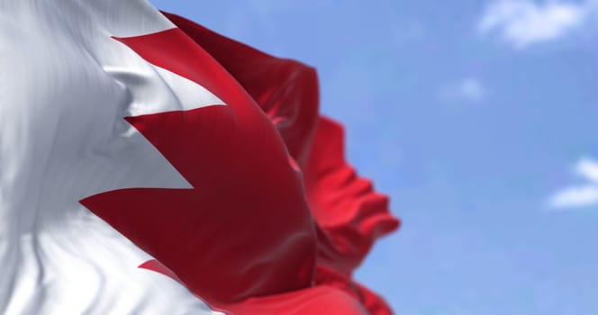 Detail of the national flag of Bahrain waving in the wind on a clear day. Democracy and politics. Patriotism. Western asian country. Selective focus.