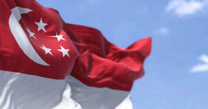 Detail of the national flag of Singapore waving in the wind on a clear day. Democracy and politics. Patriotism. South east asian country. Selective focus.