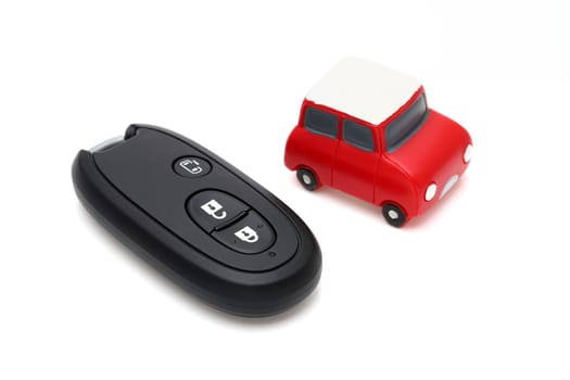 Car black key remote controller and small toy car on white background