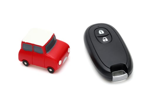 car black key remote controller and small toy car on white background