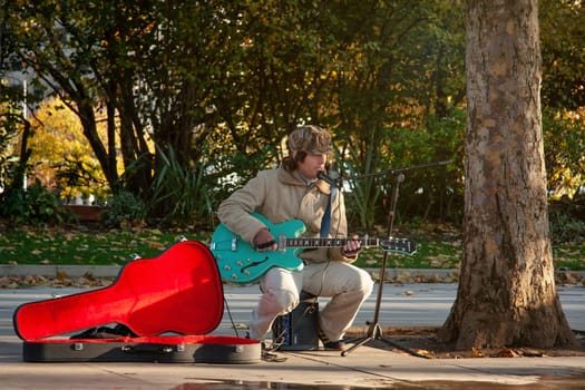 London, United Kingdom - November 18th, 2006: Unknown busker plays guitar and signs at Thames riverside. Street performers are performing often in this area, as it's popular tourist spot.