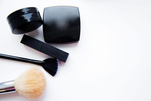 Lipstick and face powder and brush lying together on white background with place for text. High quality photo