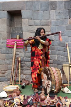 Man in typical peruvian clothes playing traditional Music for tourists in Cusco. Peru