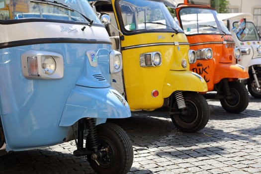 Tuk Tuk Taxis in front of Lisbon Cathedral are waiting for Tourists in Lisbon. Portugal